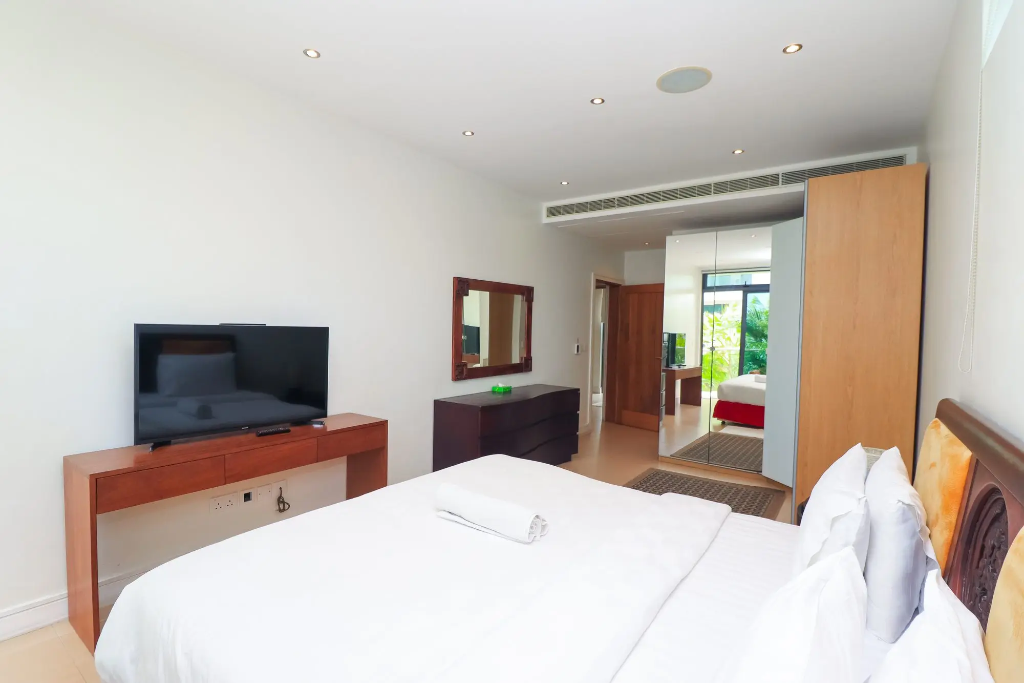 Master bedroom with dresser, mirror and TV area at Nyali Marina Stays serviced apartment, Mombasa